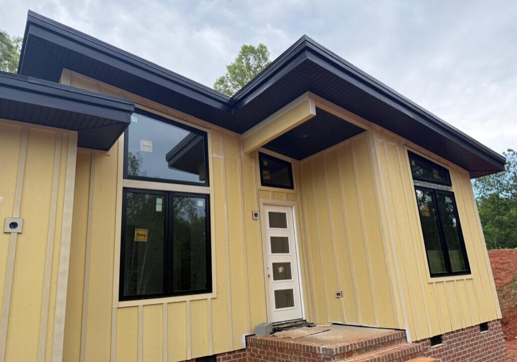 Modern yellow house with large windows.